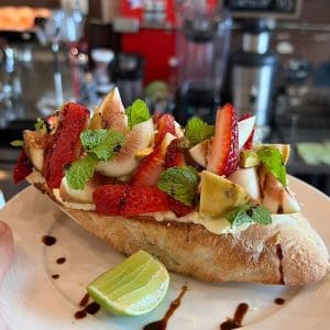 Open-face brunch toast topped with strawberries, figs and mint at The Larder Cafe & Bar