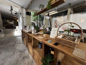 Fringe.th's wooden counter and shelving dotted with plants over a polished concrete floor