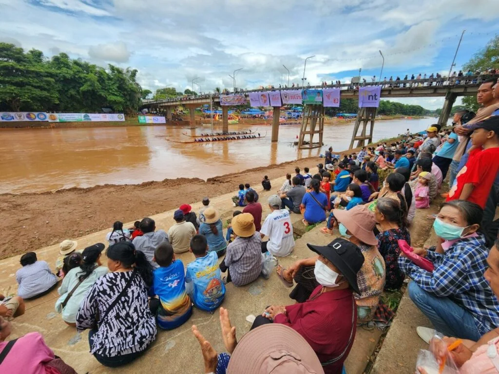Spectators watching traditional longboat racing on the Nan River