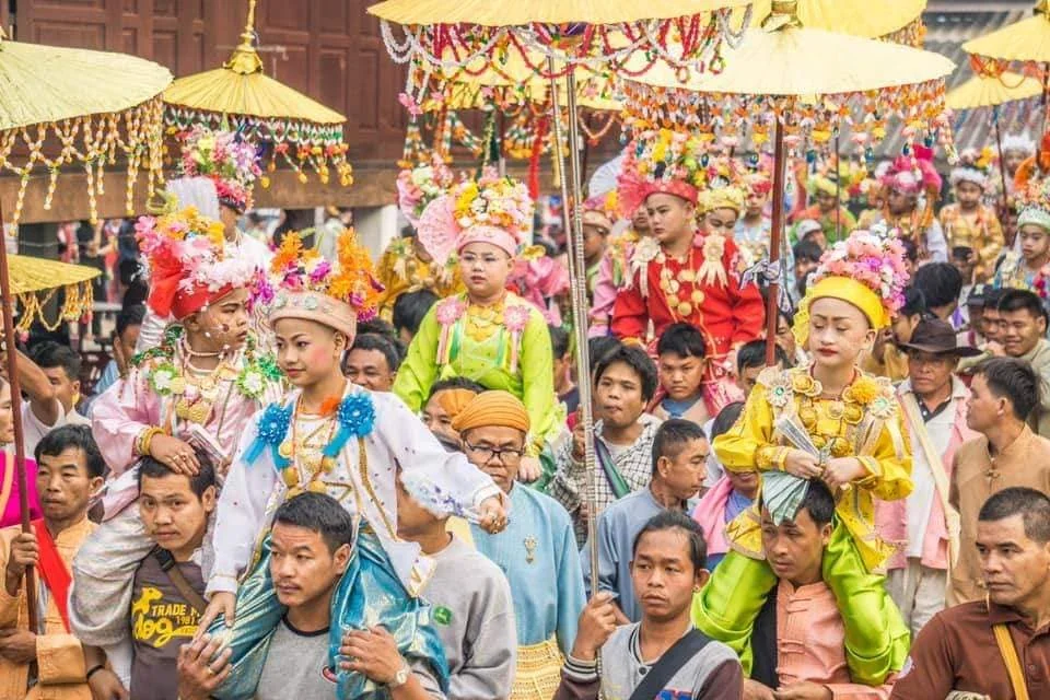 Young Poy Sang Long novices in colourful robes beneath parasols