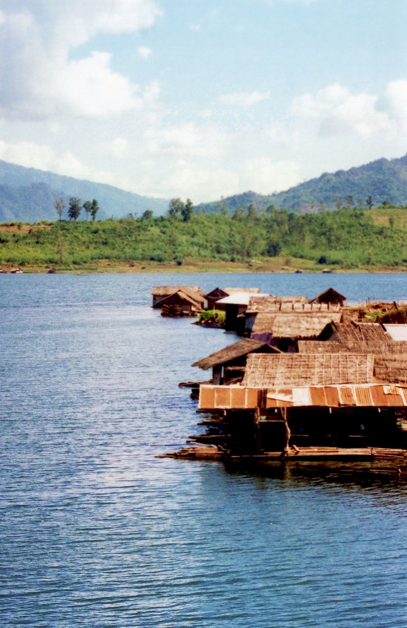 Bamboo huts floating on a mountain-ringed reservoir