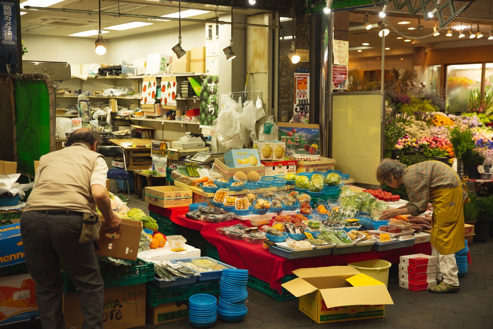 A bustling Asian fresh-grocery stall stacked with produce and boxed fruit
