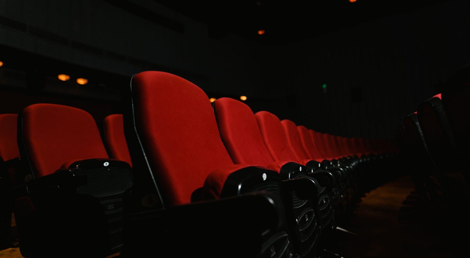 Rows of cinema seats facing a glowing screen